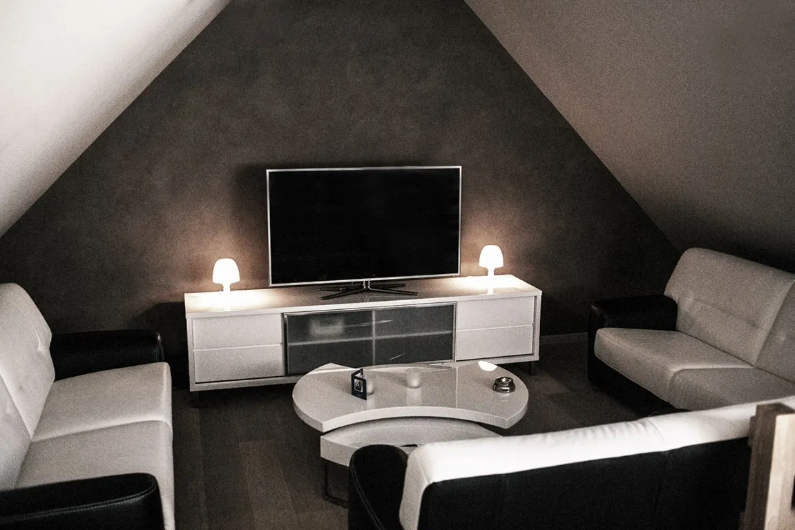 Lounge van Motel E40 met zetels en televisie